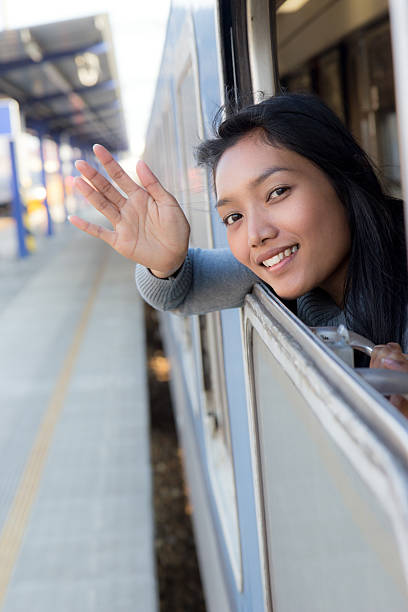 istock woman waving a greeting from moving train 476671852