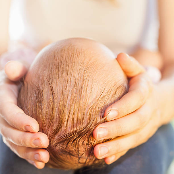 istock Mother holding baby head at hands 476672164