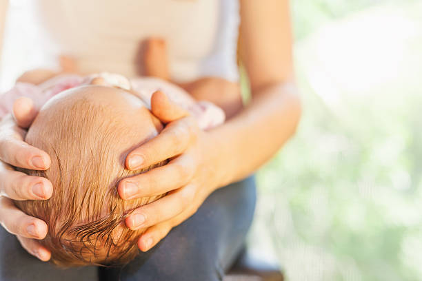 istock Mother holding baby head at hands 476672200