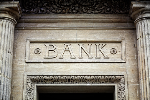 An old fashioned sign in carved stone, formerly over the entrance of a retail bank.