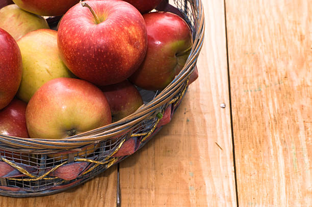 istock Red apples in basket on brown wooden background 476685306