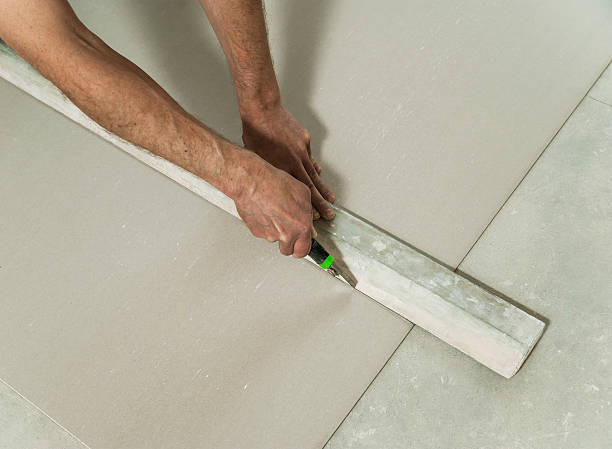 istock Man cuts off a piece of drywall 476693702