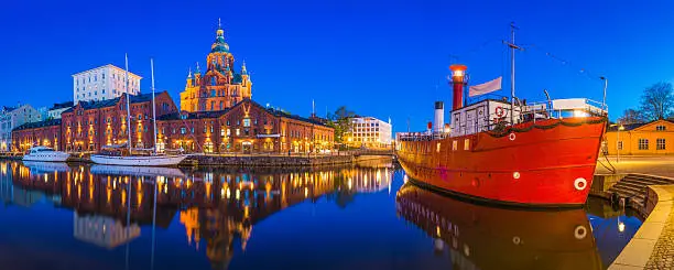 The iconic domes of Uspenski Cathedral overlooking the redeveloped warehouses, restaurants and waterfront apartments of Katajanokka and the boats moored in the tranquil blue waters of the north habour in the heart of Helsinki, Finland's vibrant capital city. ProPhoto RGB profile for maximum color fidelity and gamut.