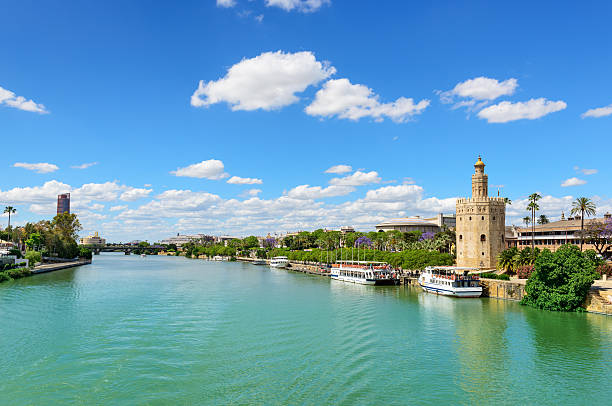 Guadalquivir River and the Golden Tower Guadalquivir River and the Golden Tower (Torre del Oroa in Spanish) of Seville is a military watchtower in Seville, Spain. It is located on the shore of the Guadalquivir River and the most emblematic symbols of Seville. It was built between 1220 and 1221 and one of the oldest buildings in Seville, Spain. seville stock pictures, royalty-free photos & images