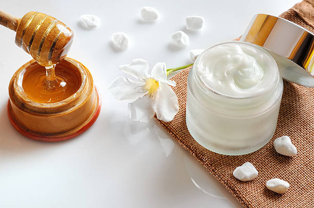 istock Honey moisturizer with stones and flower top view 476700074