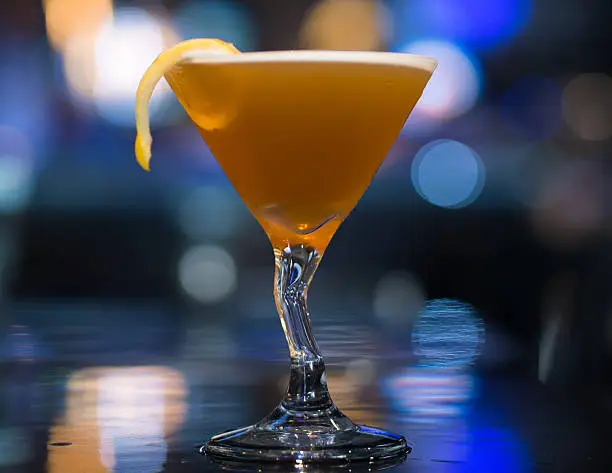 A timeless Sidecar Cocktail garnished with a lemon twist.  