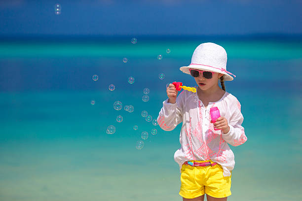istock Adorable little girl making soap bubbles during summer vacation 476701994