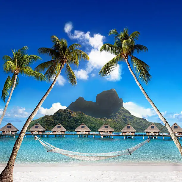 View of the Otemanu mountain through the palms with hammock and ocean. Bora-Bora. Polynesia