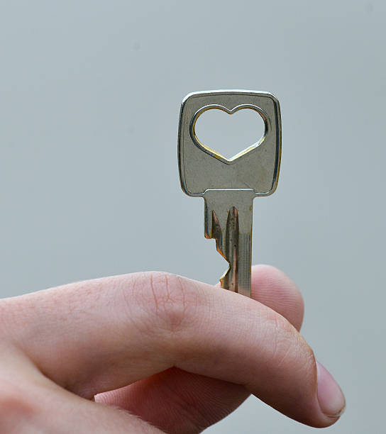 istock Hand holding key isolated on gray background 476702740