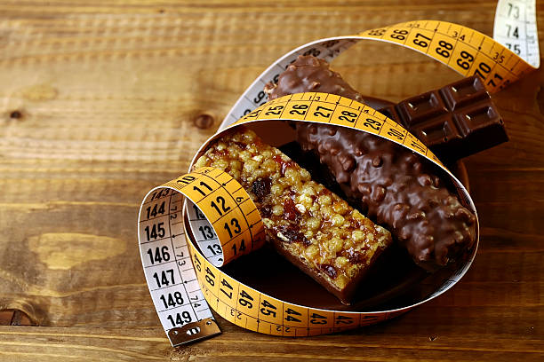 istock Delicious chocolate bars and peanut brittle with a measuring tape 476702932