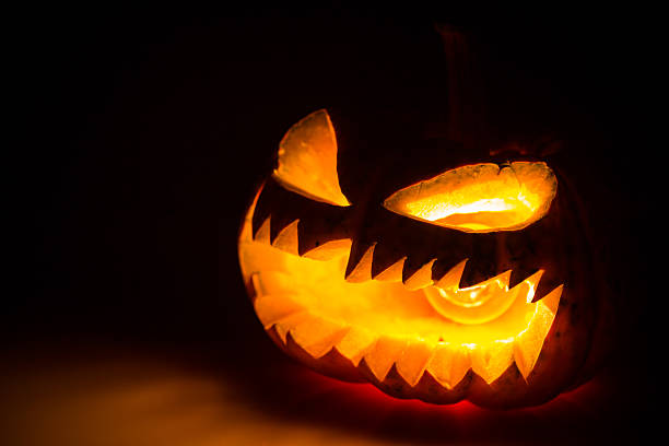 istock Halloween scary face pumpkin on black background 476709248