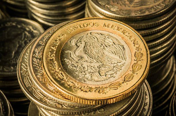 Mexican Peso Coins A golden coin with an eagle over stacks of silver coins, business wealth and success concept mexican currency stock pictures, royalty-free photos & images