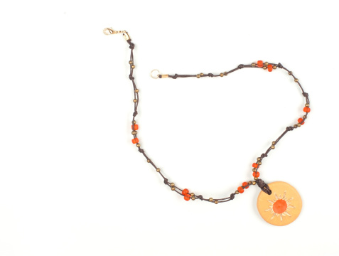 Orange handmade necklace with pendant isolted on white.