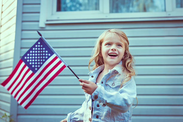 bambina sorridente bella dai capelli biondi e di bandiera americana - child flag fourth of july little girls foto e immagini stock