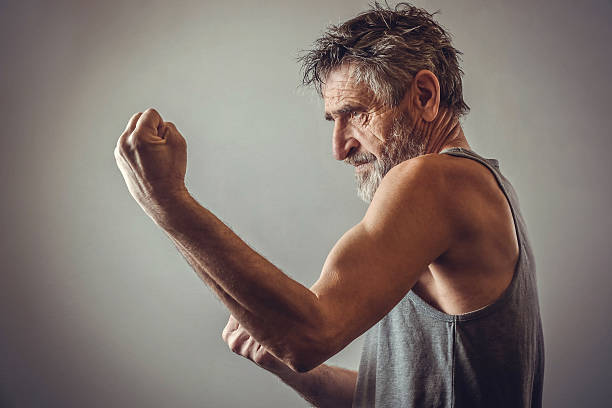 Senior man in fighting position Side view of old bearded man in fighting position old man boxing stock pictures, royalty-free photos & images