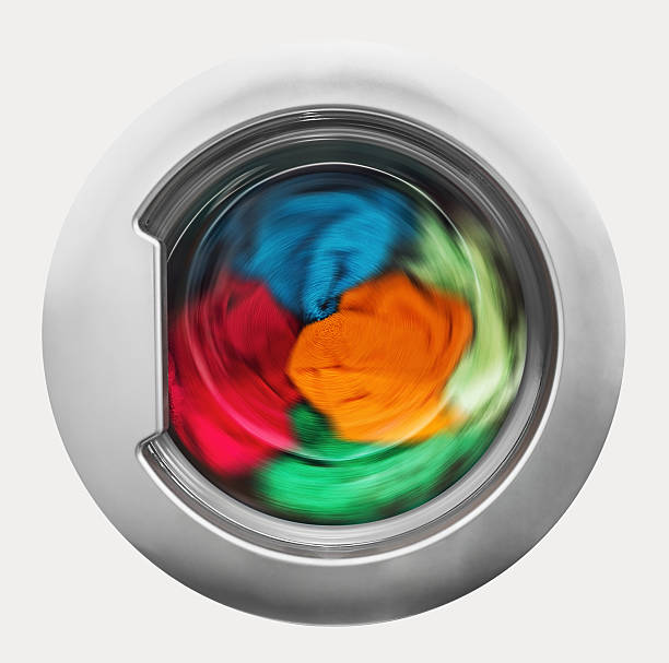 Washing machine door with rotating garments inside stock photo