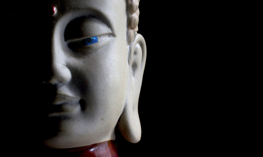 Buddha face with stone eye e black background