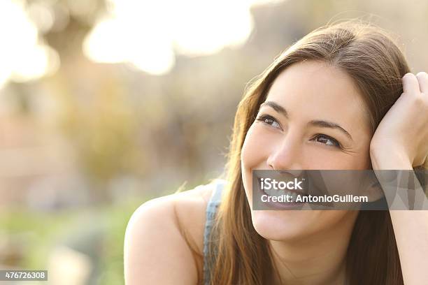 Woman With White Teeth Thinking And Looking Sideways Stock Photo - Download Image Now