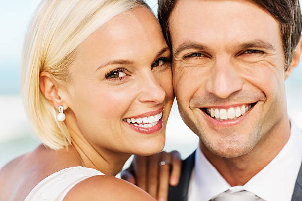 istock Newlywed Couple Smiling On Beach 476728845