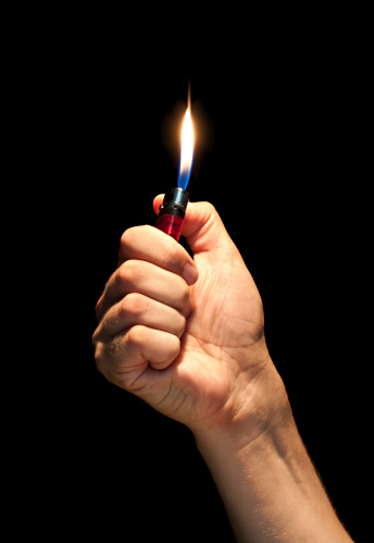 Man hand holding burning lighter