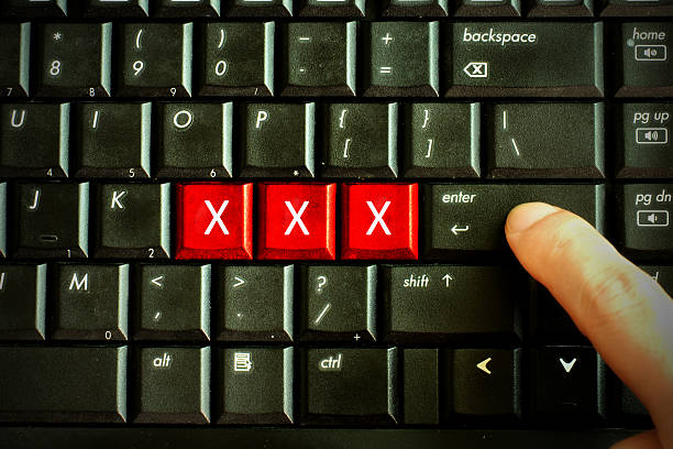 dito premere il pulsante rosso parole chiave di sesso sulla tastiera del computer, per adulti - sleaze foto e immagini stock