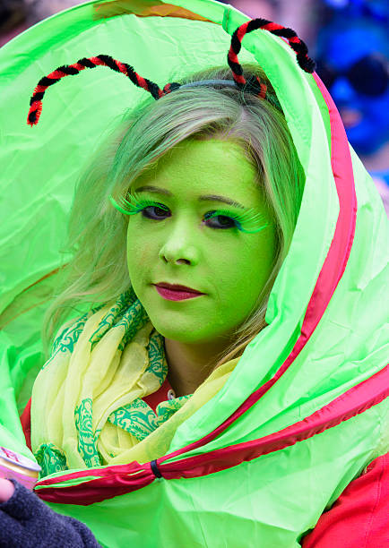 Bad Hindelang, Germany - Februar 15, 2015: Unknown person participates at the annual public carnival parade through the streets of city Bad Hindelang in southern part of Bavaria. The actor is disguised as Clown with painted face, wig with green hairs and dressed in colorful hand made costum.