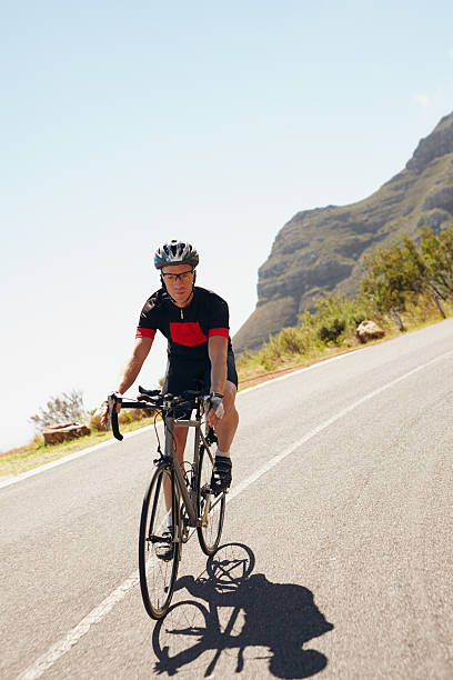 istock Male cyclist riding down a country road 476736064