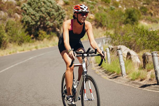 istock Young woman triathlon athlete cycling 476736072