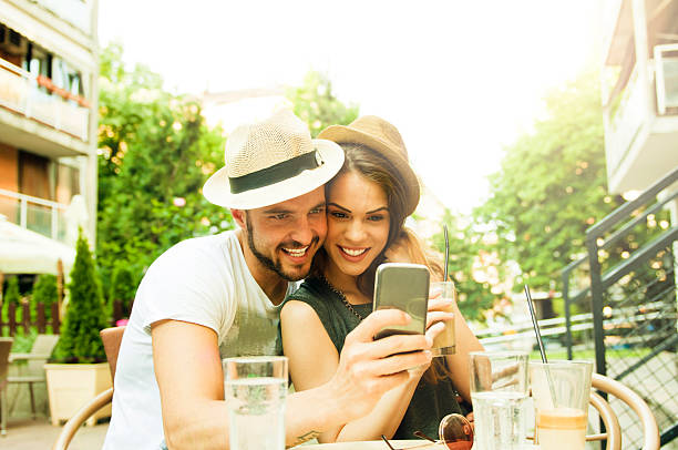istock Young happy couple at cafe using smartphone 476736098