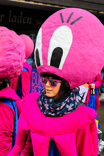 Carnival parade in Germany with spectacularly beautiful costums Bad Hindelang, Germany - Februar 15, 2015: Unknown person participates at the annual public carnival parade through the streets of city Bad Hindelang in southern part of Bavaria. The actor is disguised as in hand made costum with big hat, styled as pink head of an octopus with big eyes. mardi gras body painting stock pictures, royalty-free photos & images
