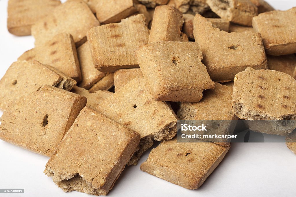 Dog biscuit pile Big pile of broken dog treats on white surface Broken Stock Photo