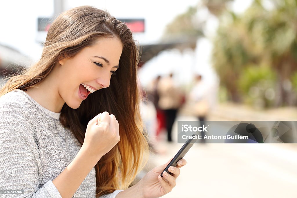 VITALISIERENDES Frau vor Ihrem Smartphone in einen Bahnhof - Lizenzfrei Handy Stock-Foto