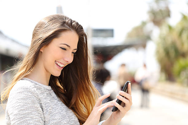 istock Girl texting on a smart phone in a train station 476739214