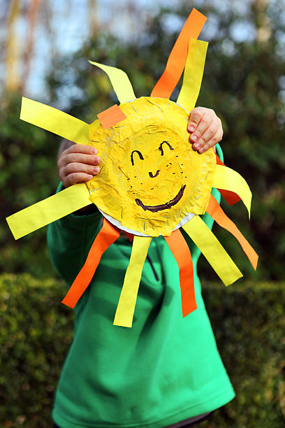 istock Child Holding Paper Sun with a Smiley Face 476740280