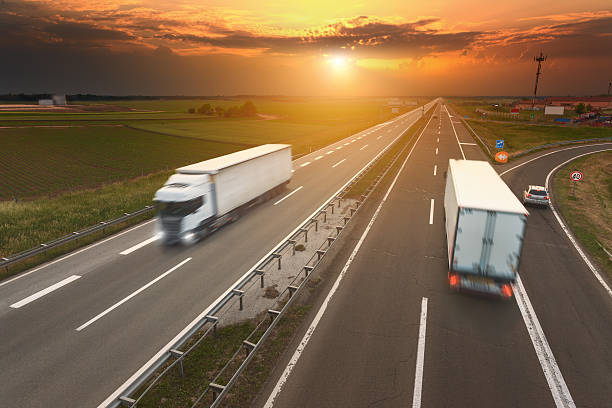 istock Two trucks in motion blur on the highway at sunset 476742832
