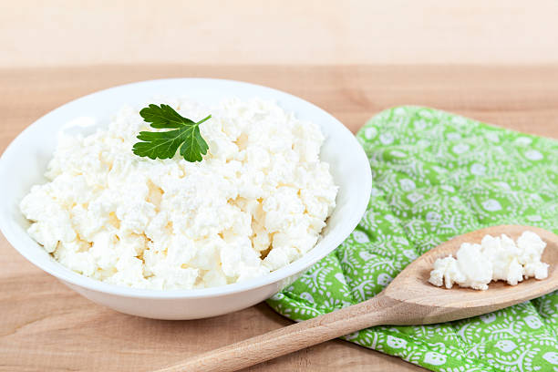 istock Fresh cottage cheese in a white bowl with spoon. 476743380