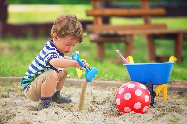 Little boy Young boy playing in the playground in summertime baby squatting stock pictures, royalty-free photos & images