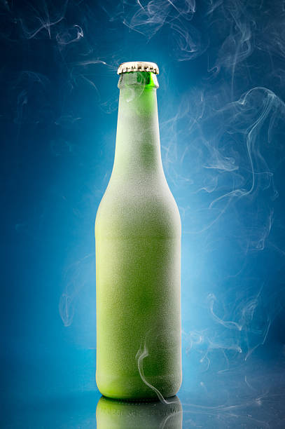 Cold beer bottle Chilled beer bottle on blue background frost on glass stock pictures, royalty-free photos & images