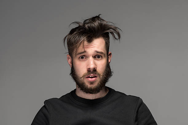 retrato de hombre joven tousled en estudio - despeinado fotografías e imágenes de stock