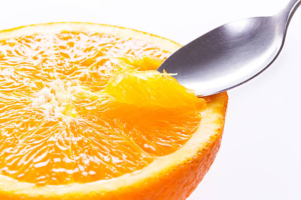 istock Orange close up.Eating with spoon. Macro.isolated on white. 476744114