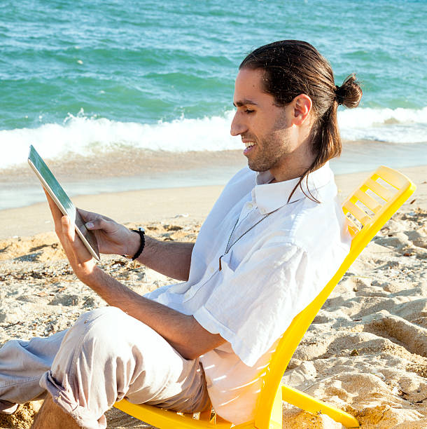 istock Happy man on the beach with digital tablet 476746904