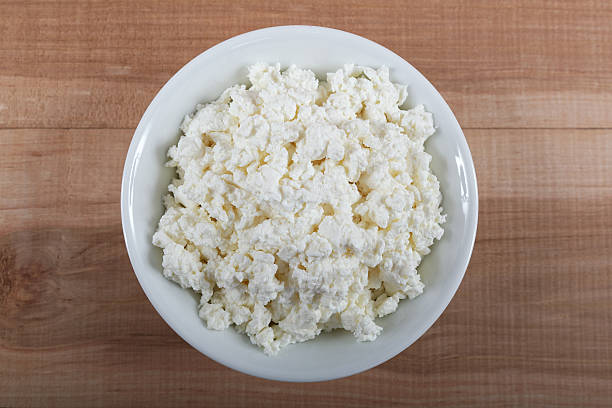 istock Fresh cottage cheese in a white bowl on a wooden. 476752106