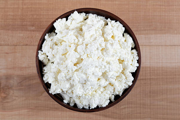 istock Fresh cottage cheese in a bowl on a wooden table. 476752190