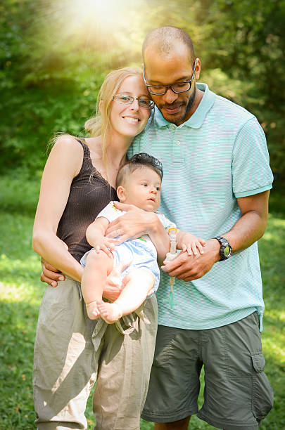 счастливый interracial семья, наслаждаясь день в парке - adoption family multi ethnic group human teeth стоковые фото и изображения