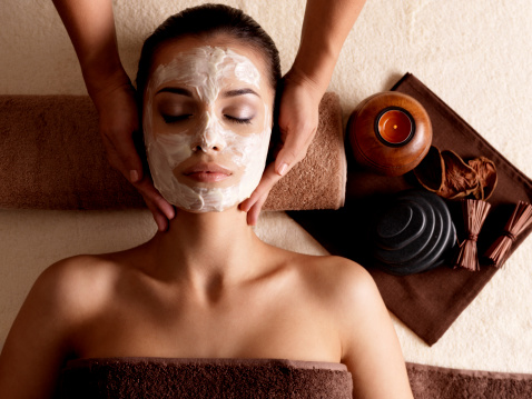 Mujer con máscara facial recibir sesión de masajes en el spa photo