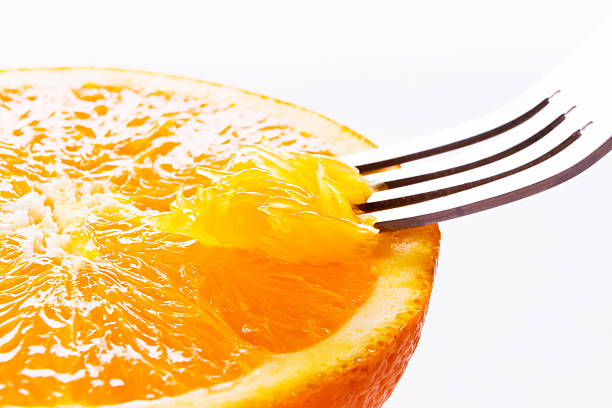istock Orange close up.Eating with fork. Macro.isolated on white. 476756330