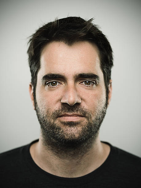 Portrait of a caucasian real young man Portrait of a real caucasian young man with neutral expression. Brown eyes and hair with beard. 35 years old australian. Vertical color image from a dslr camera in studio. istockalypse stock pictures, royalty-free photos & images