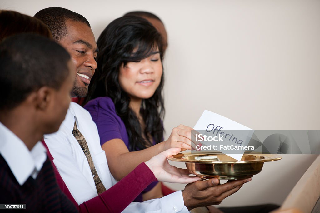 Tithe and Offering People giving tithes and offerings in church 2015 Stock Photo