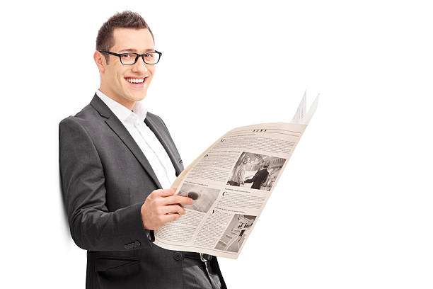 istock Happy young businessman reading a newspaper and leaning against 476758064