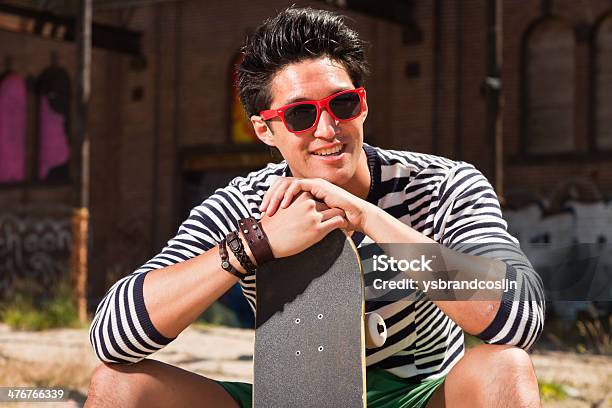 Urban Asiática Hombre Con Gafas De Sol Rojo Y Monopatín Foto de stock y más banco de imágenes de A la moda